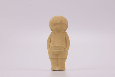 Figurine en grès d'un petit garçon debout les mains dans les poches. 