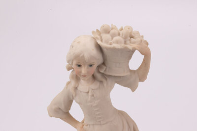 Jeune paysanne avec son panier de fruits en porcelaine et un socle en bois. Cette figurine de Giuseppe Armani date des années 80