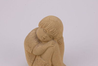 Figurine en grès d'un petit garçon dormant assis et recroquevillé sur ses genoux les bras dans le dos