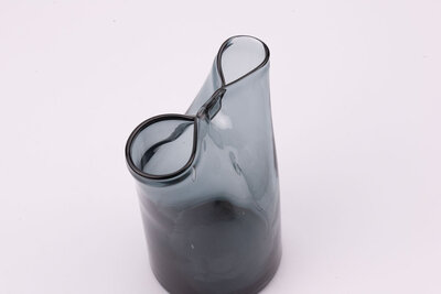 Vase en verre avec un dégradé bleuâtre, grisâtre. Le sommet de l'objet forme une légère fermeture