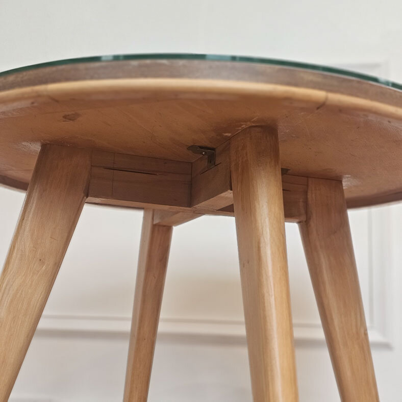 Table basse en bois clair massif dans un design très épuré.  De style scandinave, les pieds sont en bois très clair.  Le plateau de la table est fait de bois plus foncé et est travaillé avec les lignes dans le bois. Il est surmonté d'une plaque en verre épaisse.
