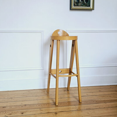 Tabouret Baumann en très bon état, un style unique avec son assise ronde et son mini-dossier. 