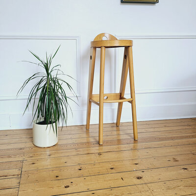 Tabouret Baumann en très bon état, un style unique avec son assise ronde et son mini-dossier. 