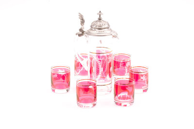 Cette cruche et ses 6 verres sont en cristal de bohème en rouge et blanc, finement ciselés. 