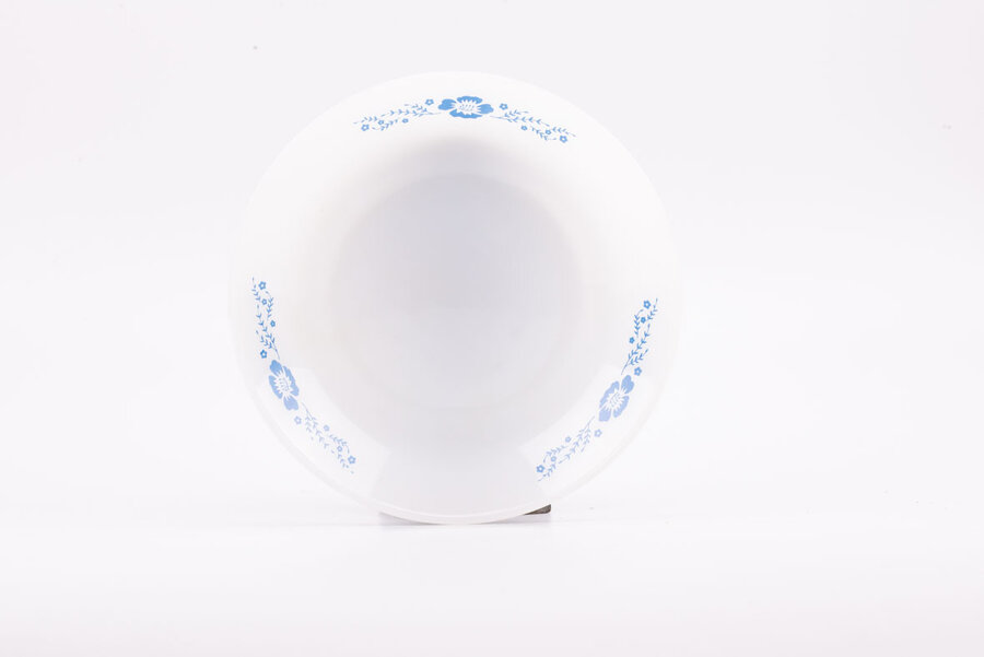 Assiette creuse vintage en opaline blanche avec des motifs bleus de chez Termocrisa