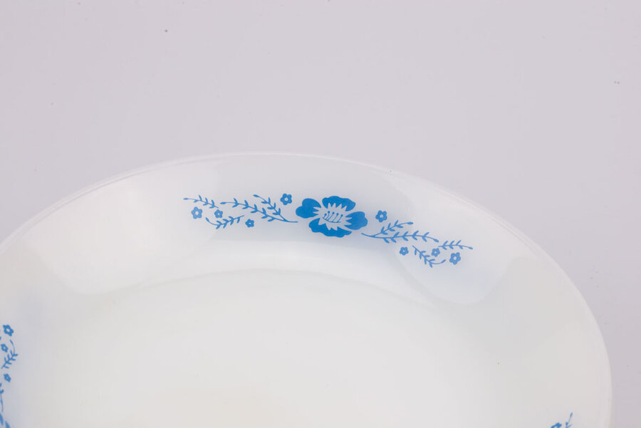 Assiette creuse vintage en opaline blanche avec des motifs bleus de chez Termocrisa