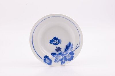 Assiette creuse en porcelaine de la manufacture française Moulin de Loup St-Amand. Ornée de motifs floraux bleus "edemond". 
