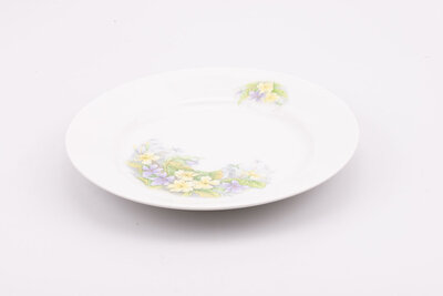 Assiette creuse en porcelaine ornée de motifs floraux délicats et esthétiques. 