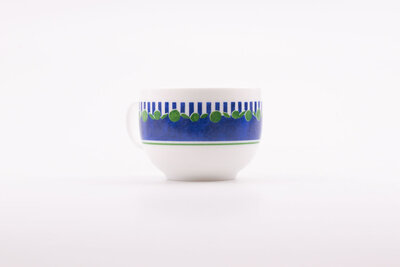 Tasse à café vintage en porcelaine blanche avec des motifs bleus et verts de chez Arcopal