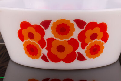 Plat à four vintage en opaline blanc avec un motif floral orange de chez Lotus Arcopal