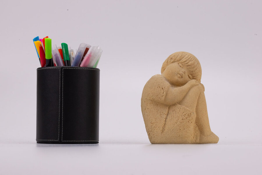 Figurine en grès d'un petit garçon dormant assis et recroquevillé sur ses genoux les bras dans le dos