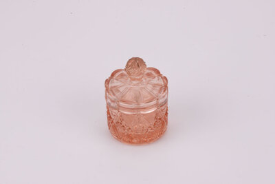 Délicat pot rose en verre avec son couvercle avec un léger éclat sur le dessus