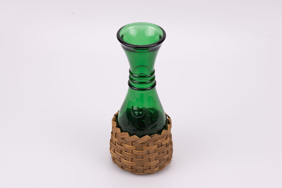 Carafe en verre très épais de couleur verte avec un socle en osier tressé