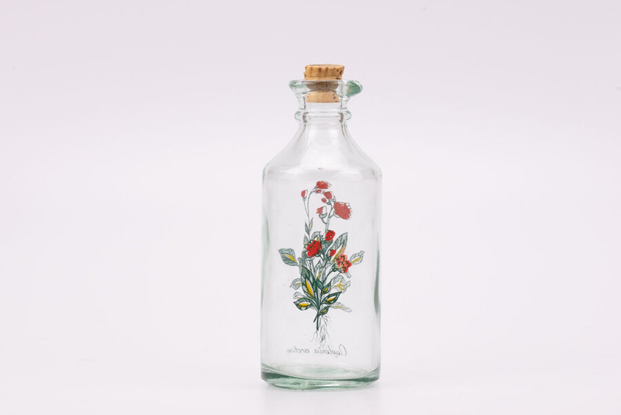 Flacon vintage en verre à bec verseur avec une fleur de Sibérie comme motif