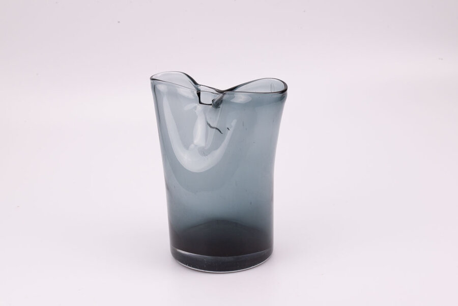 Vase en verre avec un dégradé bleuâtre, grisâtre. Le sommet de l'objet forme une légère fermeture