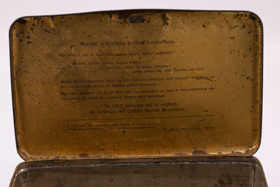 Ancienne boite en métal avec des dessins avec plein de chevaliers médiévaux avec des touches de bleu, blanc et de métal avec un texte écrit en néerlandais