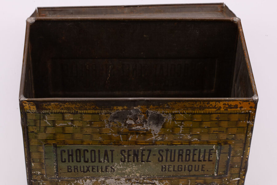 Ancienne boite en métal avec des peintures de panier en osier qui paradoxalement donne impression de coffre-fort avec des teintes dorées-brunes de la marque belge de chocolat Senez-Sturbelle