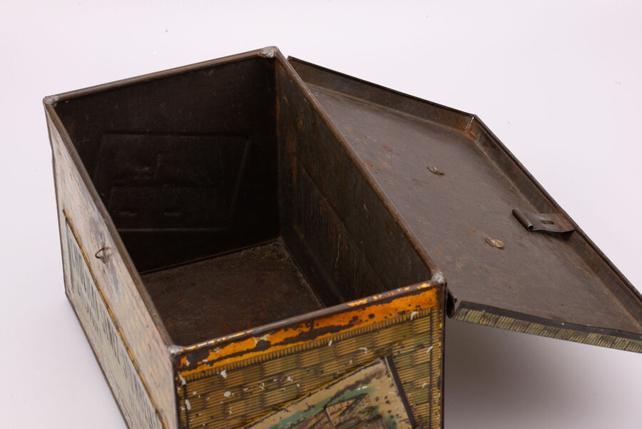 Ancienne boite en métal avec des peintures de panier en osier qui paradoxalement donne impression de coffre-fort avec des teintes dorées-brunes de la marque belge de chocolat Senez-Sturbelle