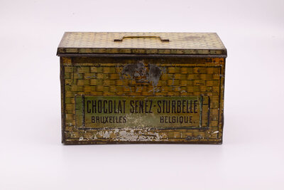 Ancienne boite en métal avec des peintures de panier en osier qui paradoxalement donne impression de coffre-fort avec des teintes dorées-brunes de la marque belge de chocolat Senez-Sturbelle