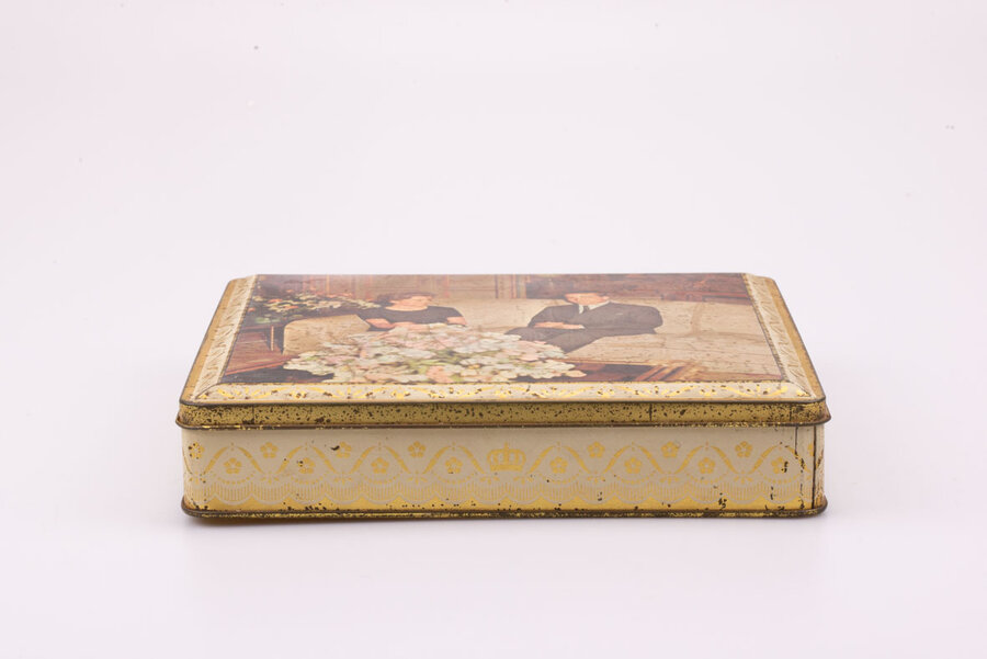 boite en métal avec des teintes jaunâtres et un dessin d'Albert et Paola dans les années 1959 de la marque Delacre.