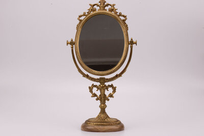 Miroir coiffeuse doré soutenu par un pied en marbre