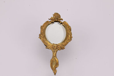 Miroir face à main en bronze, fin 19ème- début 20ème,  au décor de vagues, feuilles d’acanthe et fleurs. Traces du temps : miroir piqué. 