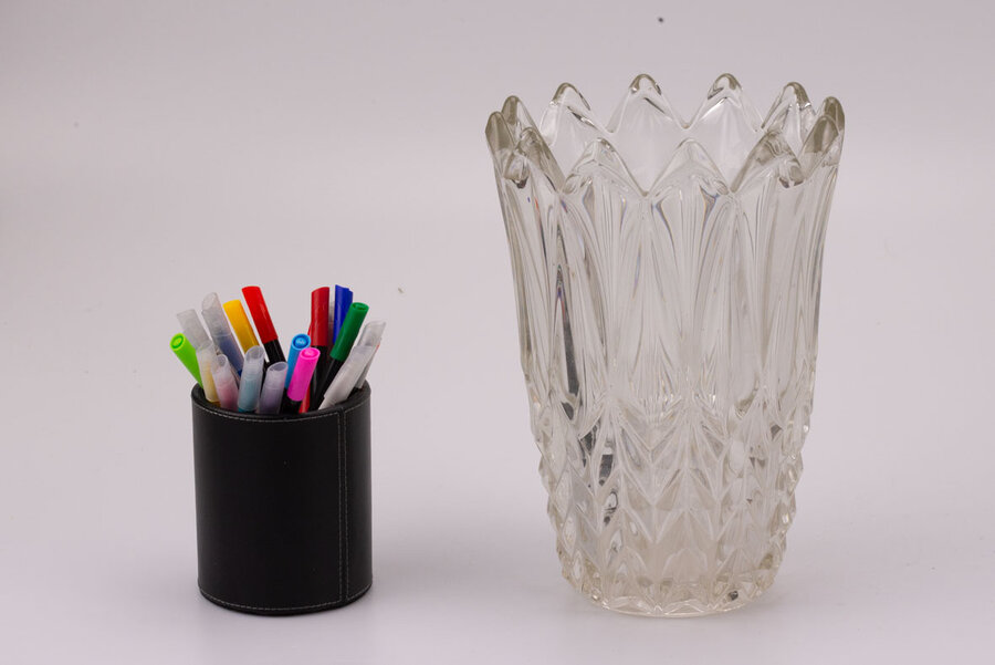 Imposant vase en verre avec son extrémité supérieur en forme de couronne et l'entièreté de l'objet est sculptée avec des formes triangulaires.