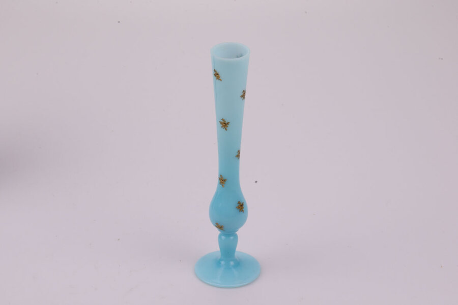 Ce délicat soliflore offre une teinte bleue opaline éclatante et présente de petits motifs fleuris dorés. 